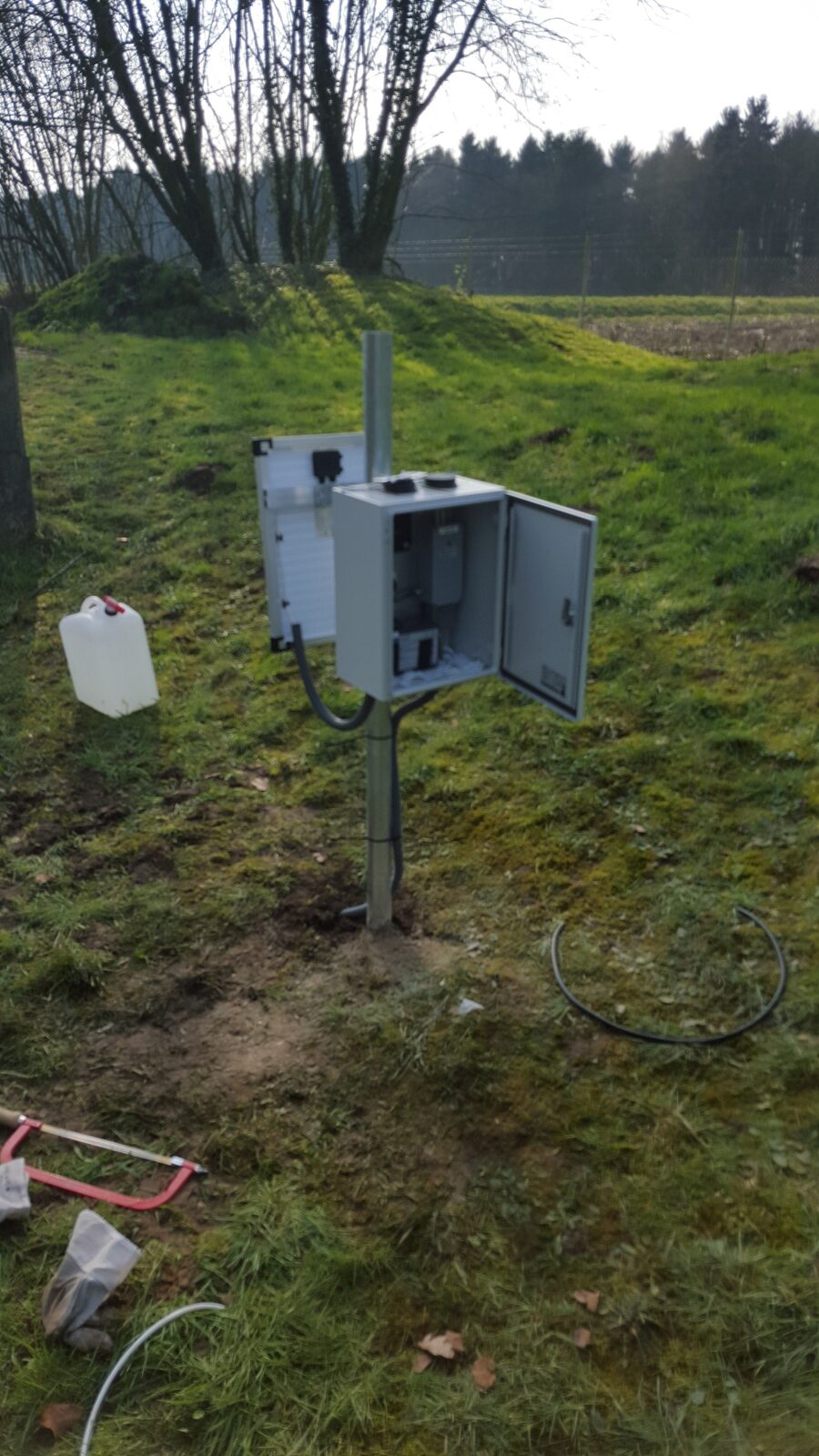 Geopende peil-schakelkast in het grasland, vers geïnstalleerd meetstation