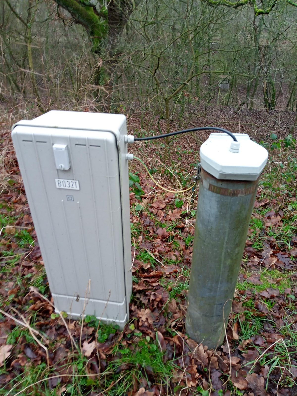 Grondwater-meetpunt in het bos met schakelkast en peilmonument