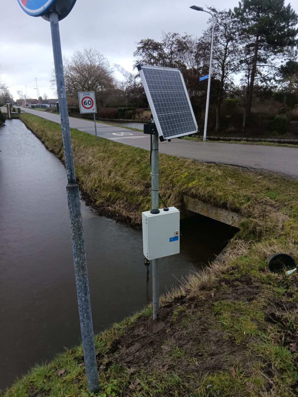 Peilstation bij een wegduiker in Nederland, met zonnepaneel en sensorkast